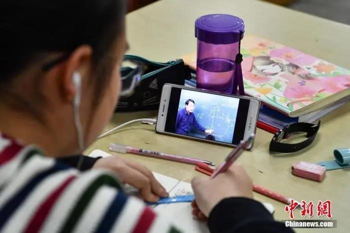 一位学生在图书馆自习室内写作业。资料图